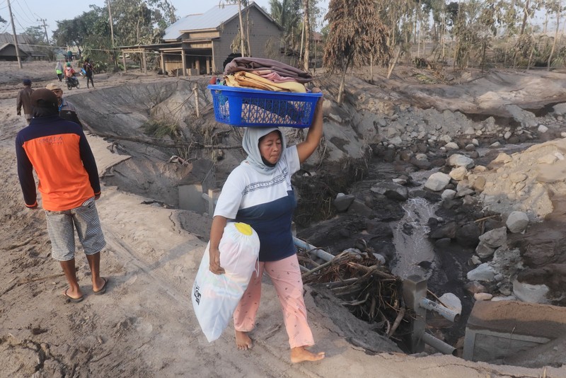 1245371309 LUMAJANG, INDONESIA - DECEMBER 5: Residents are seen rescuing their property and livestock after the eruption of Mount Semeru in Kajar Kuning Village, Lumajang, East Java Province, Indonesia on December 5, 2022. According to data from the East Java Regional Disaster Management Agency, at least 2,219 people fled after the eruption of Mount Semeru that occurred yesterday. (Photo by Suryanto/Anadolu Agency via Getty Images)