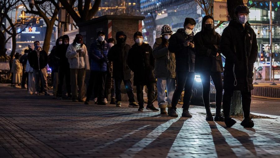 BEIJING, CHINA - DECEMBER 04: People line up in the cold for nucleic acid tests to detect COVID-19 at a public testing site on December 4, 2022 in Beijing, China. As part of a recent relaxing of COVID-19 control measures, the Beijing government announced that people would no longer need proof of a 48 hour negative COVID-19 test to ride public transit as of December 5. (Photo by Kevin Frayer/Getty Images)