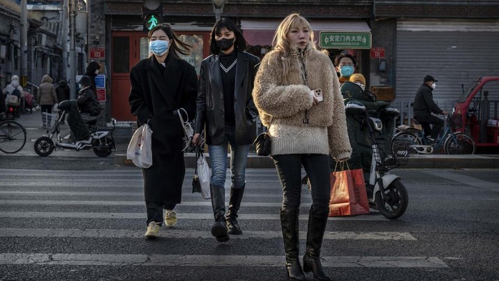 1446676556 BEIJING, CHINA - DECEMBER 04: Women, some wearing masks, cross a road near closed shops in a traditional neighbourhood on December 4, 2022 in Beijing, China. In recent weeks, China has been recording some of its highest number of COVID-19 cases since the pandemic began, while some restrictions have been relaxed, authorities are sticking to their approach to containing the virus with targeted lockdowns and testing, mask mandates, and quarantines. The government has launched a vaccination drive targeting the elderly, and indicated that some positive cases may be able to quarantine at home instead of a government facility. (Photo by Kevin Frayer/Getty Images)