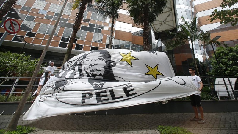 Fans mengadakan acara untuk mendukung legenda sepak bola Pele yang tetap dirawat di rumah sakit karena infeksi pernapasan di tengah perawatan kanker usus besar yang sedang berlangsung di Rumah Sakit Israel Albert Einstein pada 4 Desember 2022 di Sao Paulo, Brasil. (Mauro Horita/Getty Images)