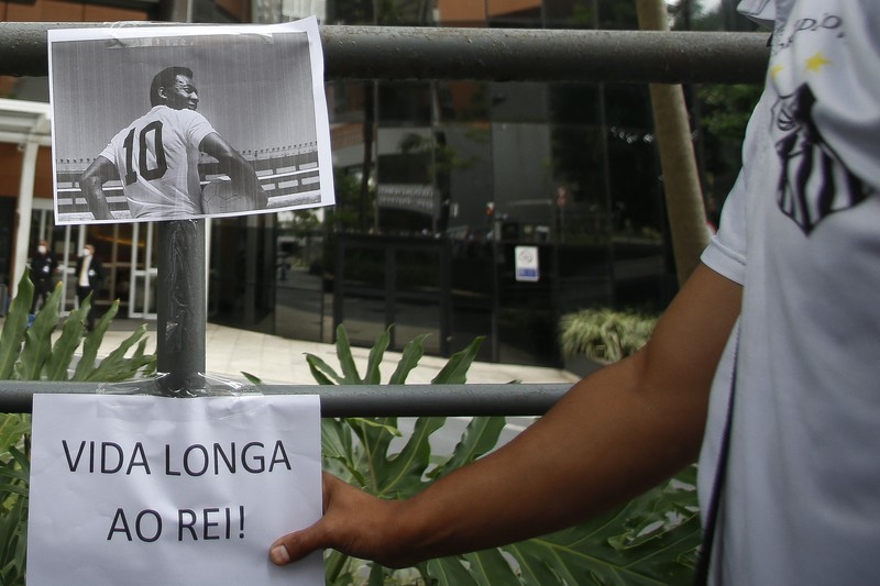 Fans mengadakan acara untuk mendukung legenda sepak bola Pele yang tetap dirawat di rumah sakit karena infeksi pernapasan di tengah perawatan kanker usus besar yang sedang berlangsung di Rumah Sakit Israel Albert Einstein pada 4 Desember 2022 di Sao Paulo, Brasil. (Mauro Horita/Getty Images)