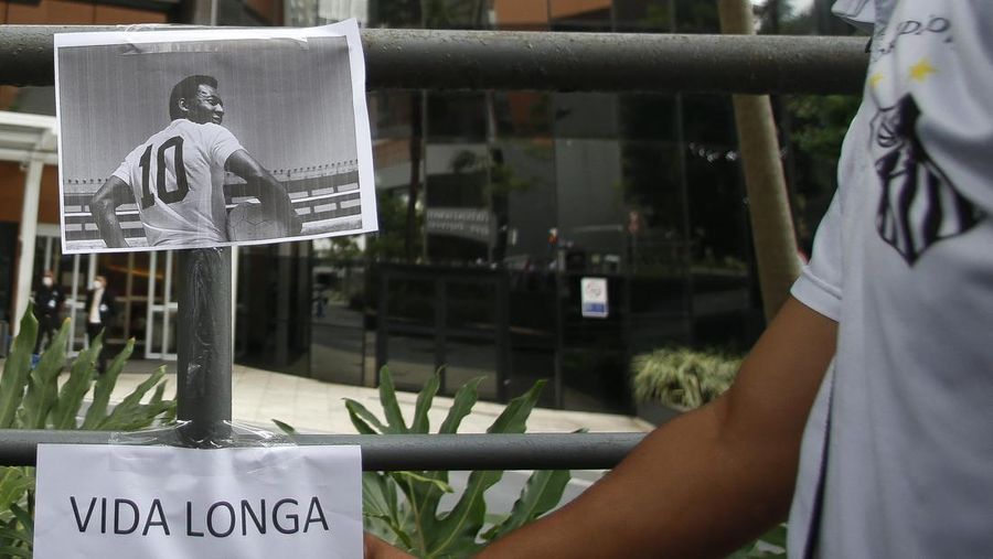 Fans mengadakan acara untuk mendukung legenda sepak bola Pele yang tetap dirawat di rumah sakit karena infeksi pernapasan di tengah perawatan kanker usus besar yang sedang berlangsung di Rumah Sakit Israel Albert Einstein pada 4 Desember 2022 di Sao Paulo, Brasil. (Mauro Horita/Getty Images)