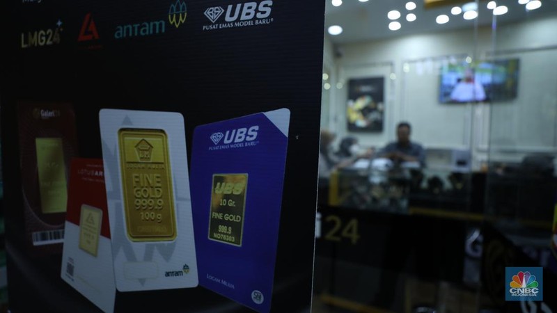 Karyawan menunjukkan emas Antam di gerai Galeri 24 Pegadaian di Jakarta, Senin (5/12/2022). Harga emas batangan di PT Pegadaian bergerak stagnan pada perdagangan hari ini, Senin (5/12/2022). Pegadaian sendiri menjual berbagai jenis emas, yaitu emas Antam, Antam Retro, Antam Batik, dan UBS. Ukurannya pun dijual beragam, mulai dari 0,5 gram hingga 1.000 gram. Pada perdagangan hari ini, harga emas Antam ukuran 1 gram dibanderol Rp 1.033.000. (CNBC Indonesia/Tri Susilo)
