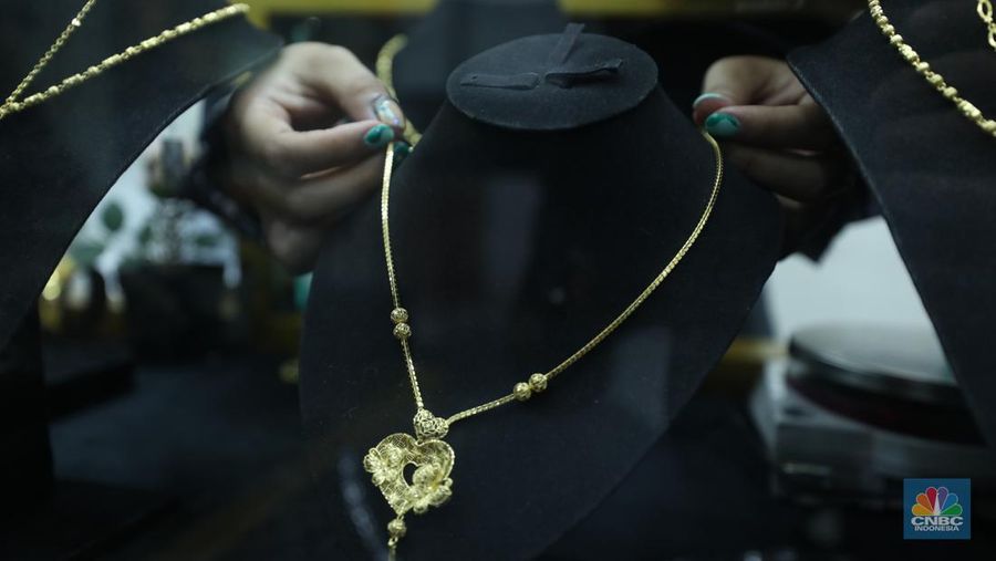 Karyawan menunjukkan emas Antam di gerai Galeri 24 Pegadaian di Jakarta, Senin (5/12/2022). Harga emas batangan di PT Pegadaian bergerak stagnan pada perdagangan hari ini, Senin (5/12/2022). Pegadaian sendiri menjual berbagai jenis emas, yaitu emas Antam, Antam Retro, Antam Batik, dan UBS. Ukurannya pun dijual beragam, mulai dari 0,5 gram hingga 1.000 gram. Pada perdagangan hari ini, harga emas Antam ukuran 1 gram dibanderol Rp 1.033.000. (CNBC Indonesia/Tri Susilo)