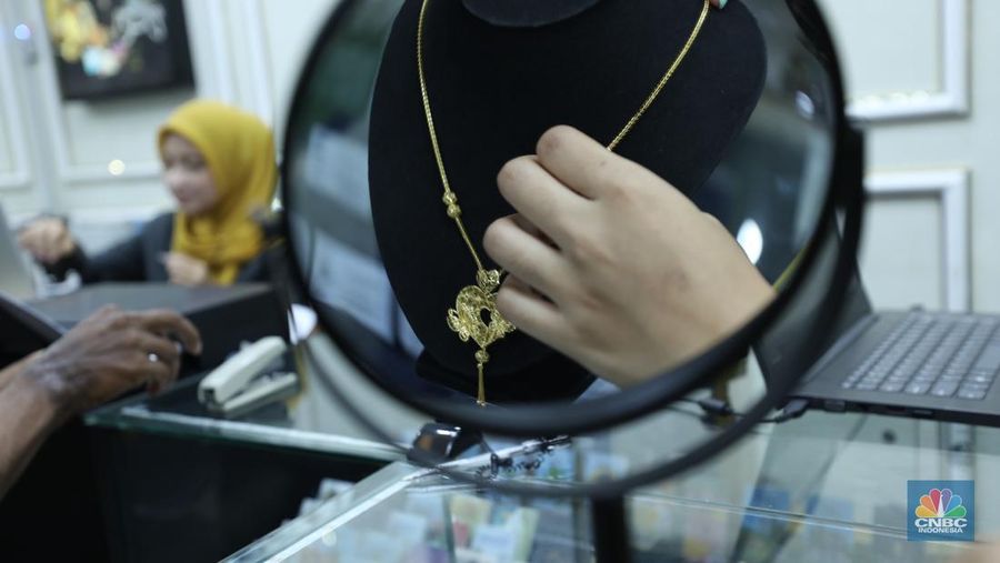 Karyawan menunjukkan emas Antam di gerai Galeri 24 Pegadaian di Jakarta, Senin (5/12/2022). Harga emas batangan di PT Pegadaian bergerak stagnan pada perdagangan hari ini, Senin (5/12/2022). Pegadaian sendiri menjual berbagai jenis emas, yaitu emas Antam, Antam Retro, Antam Batik, dan UBS. Ukurannya pun dijual beragam, mulai dari 0,5 gram hingga 1.000 gram. Pada perdagangan hari ini, harga emas Antam ukuran 1 gram dibanderol Rp 1.033.000. (CNBC Indonesia/Tri Susilo)