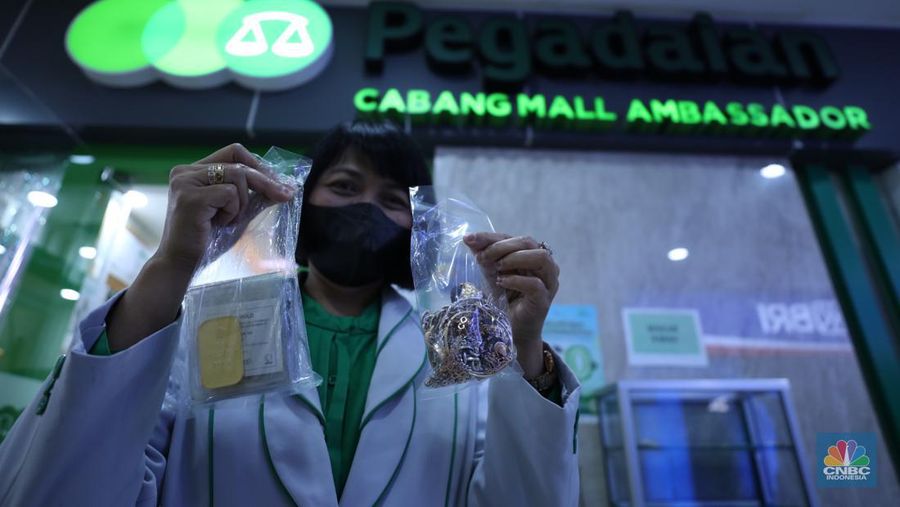 Karyawan menunjukkan emas Antam di gerai Galeri 24 Pegadaian di Jakarta, Senin (5/12/2022). Harga emas batangan di PT Pegadaian bergerak stagnan pada perdagangan hari ini, Senin (5/12/2022). Pegadaian sendiri menjual berbagai jenis emas, yaitu emas Antam, Antam Retro, Antam Batik, dan UBS. Ukurannya pun dijual beragam, mulai dari 0,5 gram hingga 1.000 gram. Pada perdagangan hari ini, harga emas Antam ukuran 1 gram dibanderol Rp 1.033.000. (CNBC Indonesia/Tri Susilo)