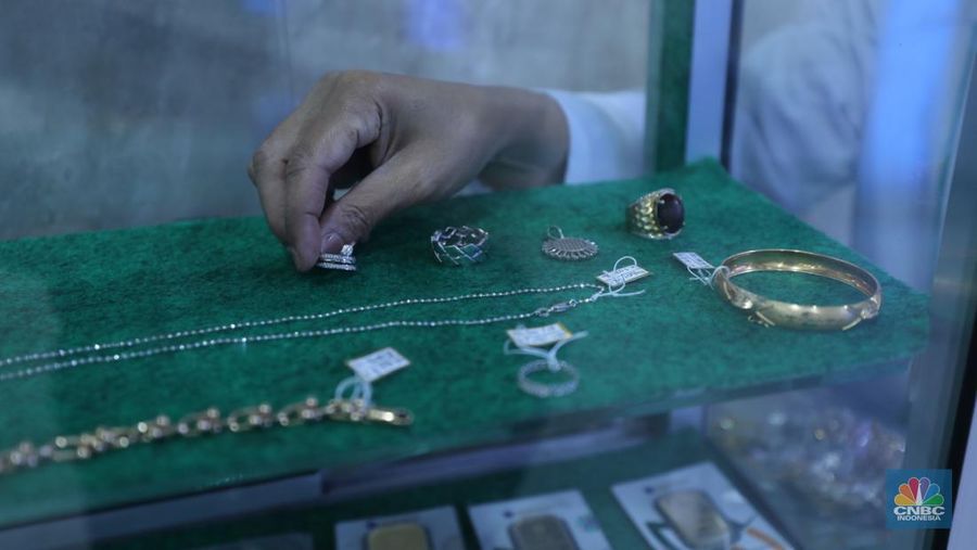 Karyawan menunjukkan emas Antam di gerai Galeri 24 Pegadaian di Jakarta, Senin (5/12/2022). Harga emas batangan di PT Pegadaian bergerak stagnan pada perdagangan hari ini, Senin (5/12/2022). Pegadaian sendiri menjual berbagai jenis emas, yaitu emas Antam, Antam Retro, Antam Batik, dan UBS. Ukurannya pun dijual beragam, mulai dari 0,5 gram hingga 1.000 gram. Pada perdagangan hari ini, harga emas Antam ukuran 1 gram dibanderol Rp 1.033.000. (CNBC Indonesia/Tri Susilo)