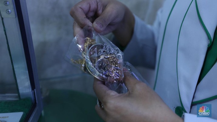 Karyawan menunjukkan emas Antam di gerai Galeri 24 Pegadaian di Jakarta, Senin (5/12/2022). Harga emas batangan di PT Pegadaian bergerak stagnan pada perdagangan hari ini, Senin (5/12/2022). Karyawan menunjukkan emas Antam di gerai Galeri 24 Pegadaian di Jakarta, Senin (5/12/2022). Harga emas batangan di PT Pegadaian bergerak stagnan pada perdagangan hari ini, Senin (5/12/2022). Pegadaian sendiri menjual berbagai jenis emas, yaitu emas Antam, Antam Retro, Antam Batik, dan UBS. Ukurannya pun dijual beragam, mulai dari 0,5 gram hingga 1.000 gram. Pada perdagangan hari ini, harga emas Antam ukuran 1 gram dibanderol Rp 1.033.000. (CNBC Indonesia/Tri Susilo)