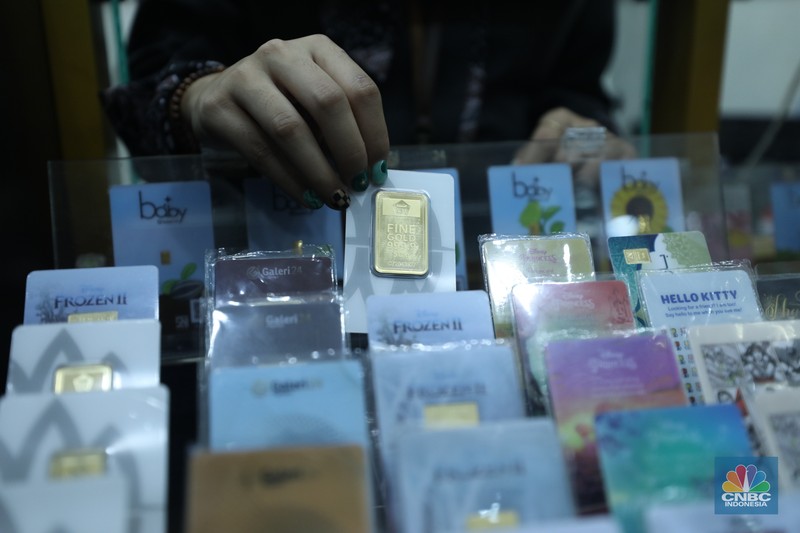 Karyawan menunjukkan emas Antam di gerai Galeri 24 Pegadaian di Jakarta, Senin (5/12/2022). Harga emas batangan di PT Pegadaian bergerak stagnan pada perdagangan hari ini, Senin (5/12/2022). Pegadaian sendiri menjual berbagai jenis emas, yaitu emas Antam, Antam Retro, Antam Batik, dan UBS. Ukurannya pun dijual beragam, mulai dari 0,5 gram hingga 1.000 gram. Pada perdagangan hari ini, harga emas Antam ukuran 1 gram dibanderol Rp 1.033.000. (CNBC Indonesia/Tri Susilo)