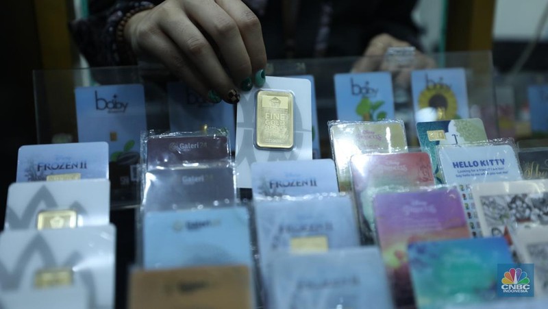 Karyawan menunjukkan emas Antam di gerai Galeri 24 Pegadaian di Jakarta, Senin (5/12/2022). Harga emas batangan di PT Pegadaian bergerak stagnan pada perdagangan hari ini, Senin (5/12/2022). Pegadaian sendiri menjual berbagai jenis emas, yaitu emas Antam, Antam Retro, Antam Batik, dan UBS. Ukurannya pun dijual beragam, mulai dari 0,5 gram hingga 1.000 gram. Pada perdagangan hari ini, harga emas Antam ukuran 1 gram dibanderol Rp 1.033.000. (CNBC Indonesia/Tri Susilo)
