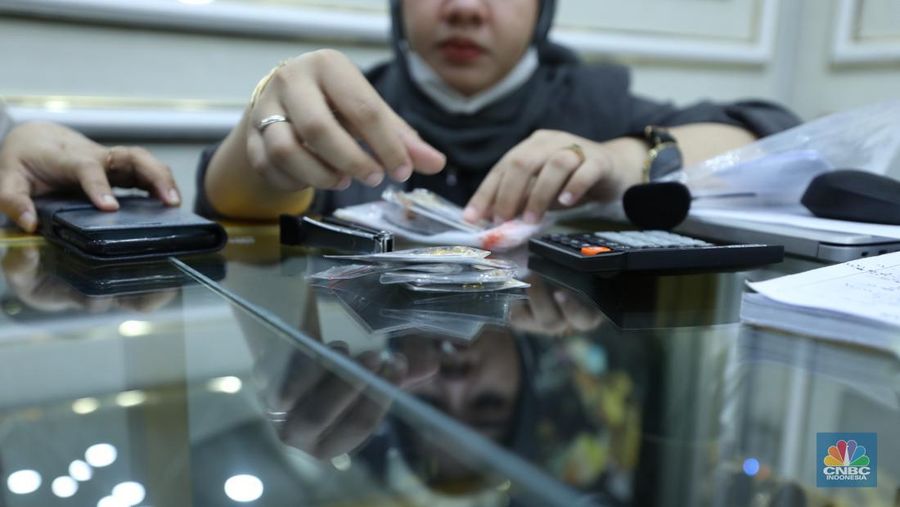 Karyawan menunjukkan emas Antam di gerai Galeri 24 Pegadaian di Jakarta, Senin (5/12/2022). Harga emas batangan di PT Pegadaian bergerak stagnan pada perdagangan hari ini, Senin (5/12/2022). Pegadaian sendiri menjual berbagai jenis emas, yaitu emas Antam, Antam Retro, Antam Batik, dan UBS. Ukurannya pun dijual beragam, mulai dari 0,5 gram hingga 1.000 gram. Pada perdagangan hari ini, harga emas Antam ukuran 1 gram dibanderol Rp 1.033.000. (CNBC Indonesia/Tri Susilo)