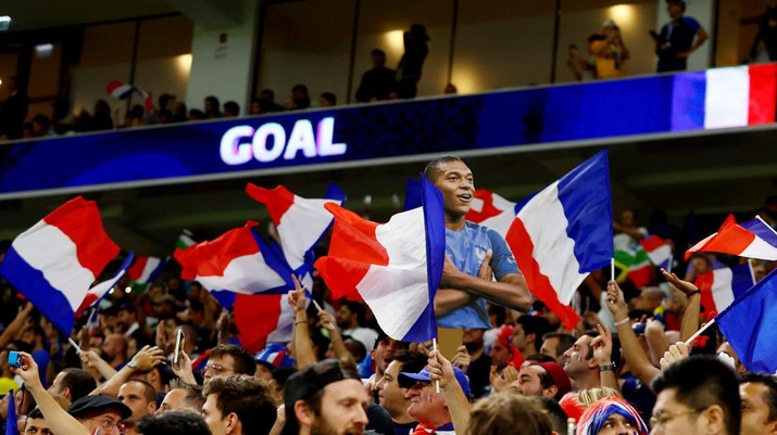 SOCCER-WORLDCUP-FRA-POL/REPORT Soccer Football - FIFA World Cup Qatar 2022 - Round of 16 - France v Poland - Al Thumama Stadium, Doha, Qatar - December 4, 2022 A cutout of France's Kylian Mbappe is held aloft as flags of France are waved by fans during the match REUTERS/Bernadett Szabo