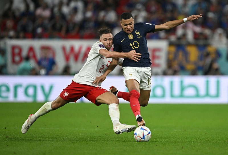Soccer Football - FIFA World Cup Qatar 2022 - Round of 16 - France v Poland - Al Thumama Stadium, Doha, Qatar - December 4, 2022 France's Kylian Mbappe in action with Poland's Matty Cash REUTERS/Dylan Martinez     TPX IMAGES OF THE DAY