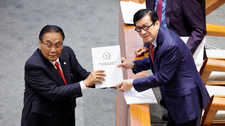 Yasonna Laoly, Indonesian Minister of Law and Human Rights, receives the new criminal code report from Bambang Wuryanto, head of the parliamentary commission overseeing the revision, during a parliamentary plenary meeting in Jakarta, Indonesia, December 6, 2022. REUTERS/Willy Kurniawan