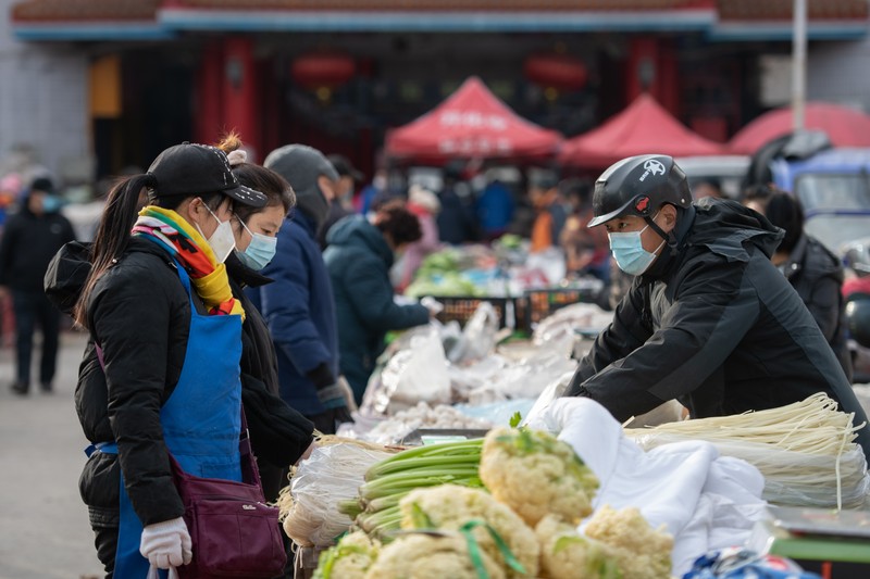 Orang-orang berbelanja sayuran di pasar basah karena Tiayuan tidak lagi mewajibkan orang untuk menunjukkan hasil tes asam nukleat negatif sebelum memasuki tempat umum pada 7 Desember 2022 di Taiyuan, Provinsi Shanxi China. (Wei Liang/China News Service via Getty Images)