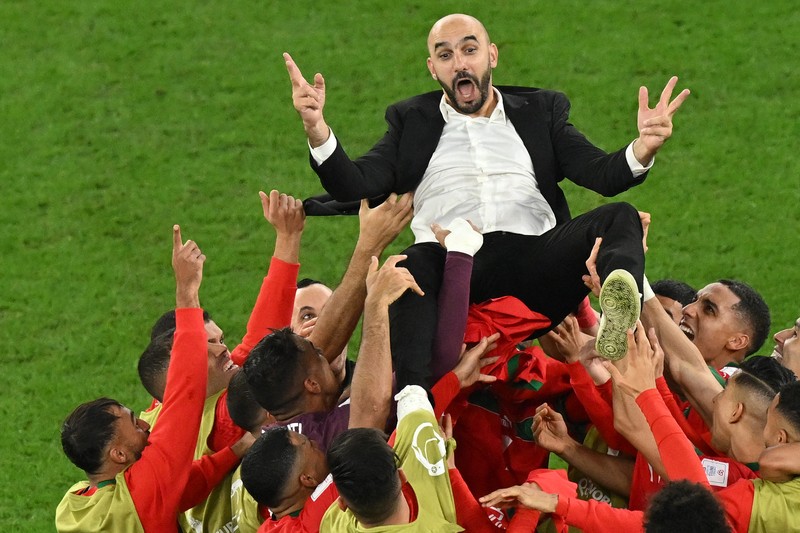 Walid Reragui, Pelatih Kepala Maroko, merayakan dengan para pemain setelah kemenangan tim dalam adu penalti selama pertandingan Babak 16 Besar Piala Dunia Qatar 2022 antara Maroko dan Spanyol di Education City Stadium pada 06 Desember 2022 di Al Rayyan, Qatar. Walid Reragui, Pelatih Kepala Maroko, merayakan dengan para pemain setelah kemenangan tim dalam adu penalti selama pertandingan Babak 16 Besar Piala Dunia Qatar 2022 antara Maroko dan Spanyol di Education City Stadium pada 06 Desember 2022 di Al Rayyan, Qatar. (Photo by Alexander Hassenstein/Getty Images)