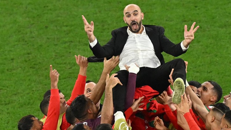 Walid Reragui, Pelatih Kepala Maroko, merayakan dengan para pemain setelah kemenangan tim dalam adu penalti selama pertandingan Babak 16 Besar Piala Dunia Qatar 2022 antara Maroko dan Spanyol di Education City Stadium pada 06 Desember 2022 di Al Rayyan, Qatar. (Photo by Alexander Hassenstein/Getty Images)
