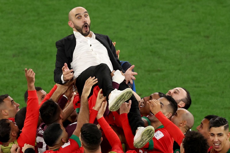 Walid Reragui, Pelatih Kepala Maroko, merayakan dengan para pemain setelah kemenangan tim dalam adu penalti selama pertandingan Babak 16 Besar Piala Dunia Qatar 2022 antara Maroko dan Spanyol di Education City Stadium pada 06 Desember 2022 di Al Rayyan, Qatar. Walid Reragui, Pelatih Kepala Maroko, merayakan dengan para pemain setelah kemenangan tim dalam adu penalti selama pertandingan Babak 16 Besar Piala Dunia Qatar 2022 antara Maroko dan Spanyol di Education City Stadium pada 06 Desember 2022 di Al Rayyan, Qatar. (Photo by Alexander Hassenstein/Getty Images)