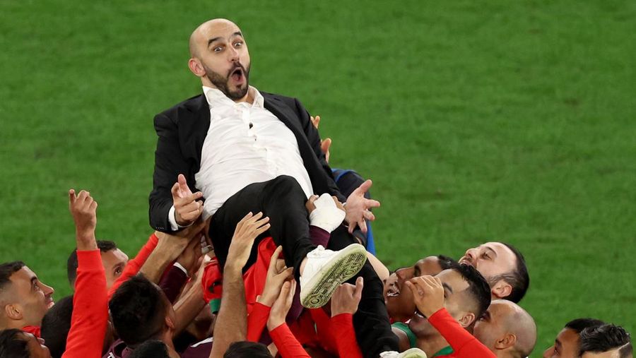 Walid Reragui, Pelatih Kepala Maroko, merayakan dengan para pemain setelah kemenangan tim dalam adu penalti selama pertandingan Babak 16 Besar Piala Dunia Qatar 2022 antara Maroko dan Spanyol di Education City Stadium pada 06 Desember 2022 di Al Rayyan, Qatar. (Photo by Alexander Hassenstein/Getty Images)