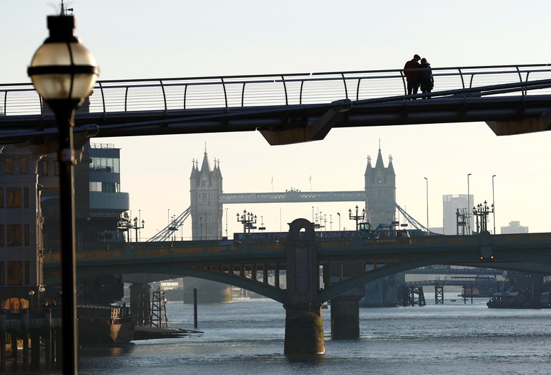BRITAIN-WEATHER/ People walk across Millennium Bridge as temperatures in London fall below zero degrees Celsius, in London, Britain, December 8, 2022. REUTERS/Peter Nicholls