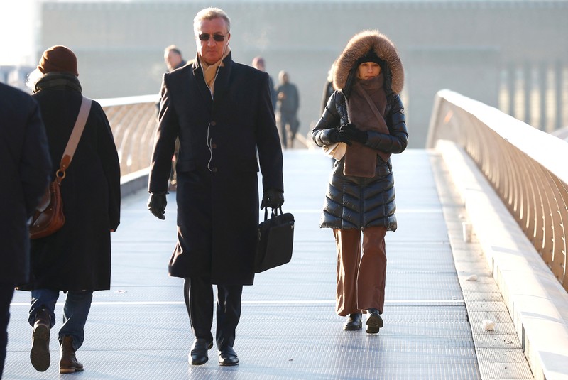 BRITAIN-WEATHER/ People walk across Millennium Bridge as temperatures in London fall below zero degrees Celsius, in London, Britain, December 8, 2022. REUTERS/Peter Nicholls