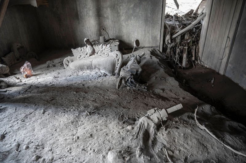 Gambar ini menunjukkan rumah warga yang terbengkalai terendam abu akibat letusan gunung Semeru pada 4 Desember di desa Kajar Kuning, Lumajang pada 6 Desember 2022. Gambar ini menunjukkan rumah warga yang terbengkalai terendam abu akibat letusan gunung Semeru pada 4 Desember di desa Kajar Kuning, Lumajang pada 6 Desember 2022. (JUNI KRISWANTO/AFP via Getty Images)