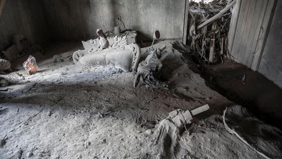 Gambar ini menunjukkan rumah warga yang terbengkalai terendam abu akibat letusan gunung Semeru pada 4 Desember di desa Kajar Kuning, Lumajang pada 6 Desember 2022. (JUNI KRISWANTO/AFP via Getty Images)