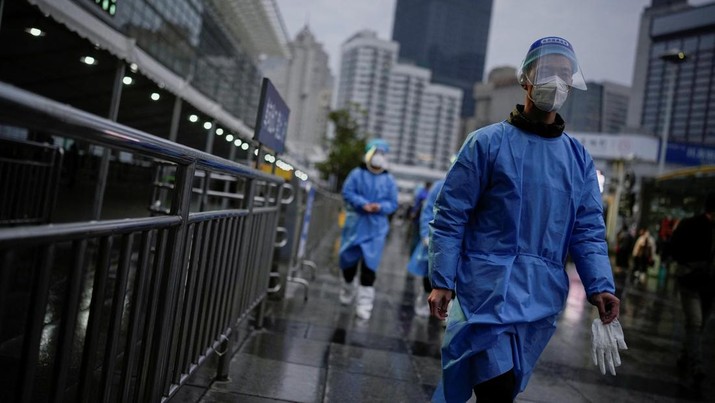 Workers in protective suits walk outside the Shanghai Railway Station as coronavirus disease (COVID-19) outbreaks continue in Shanghai, China, December 8, 2022. REUTERS/Aly Song