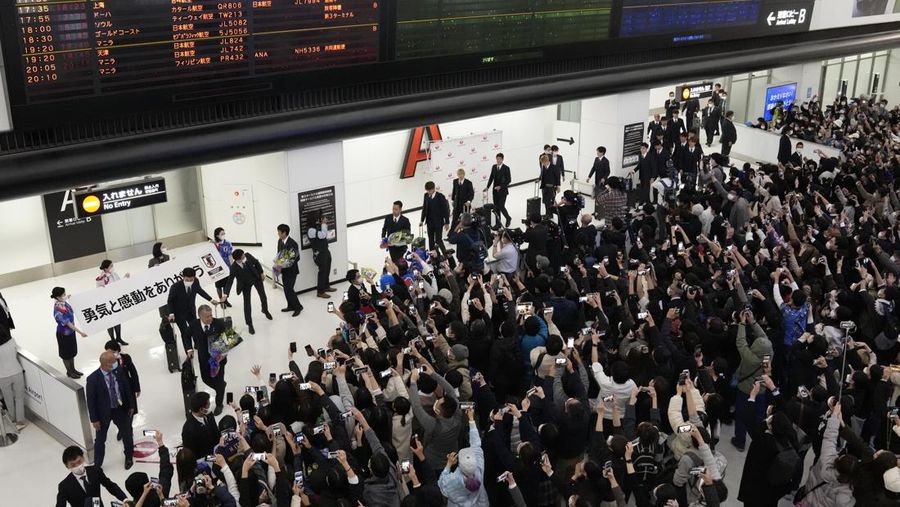 Supporters take photos of the Japanese national soccer team, including head coach Hajime Moriyasu, returning from the World Cup in Qatar at Narita International Airport in Narita, east of Tokyo Japan December 7, 2022. Mandatory credit Kyodo/via REUTERS ATTENTION EDITORS - THIS IMAGE WAS PROVIDED BY A THIRD PARTY. MANDATORY CREDIT. JAPAN OUT. NO COMMERCIAL OR EDITORIAL SALES IN JAPAN