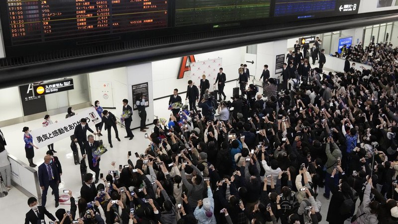 Supporters take photos of the Japanese national soccer team, including head coach Hajime Moriyasu, returning from the World Cup in Qatar at Narita International Airport in Narita, east of Tokyo Japan December 7, 2022. Mandatory credit Kyodo/via REUTERS ATTENTION EDITORS - THIS IMAGE WAS PROVIDED BY A THIRD PARTY. MANDATORY CREDIT. JAPAN OUT. NO COMMERCIAL OR EDITORIAL SALES IN JAPAN