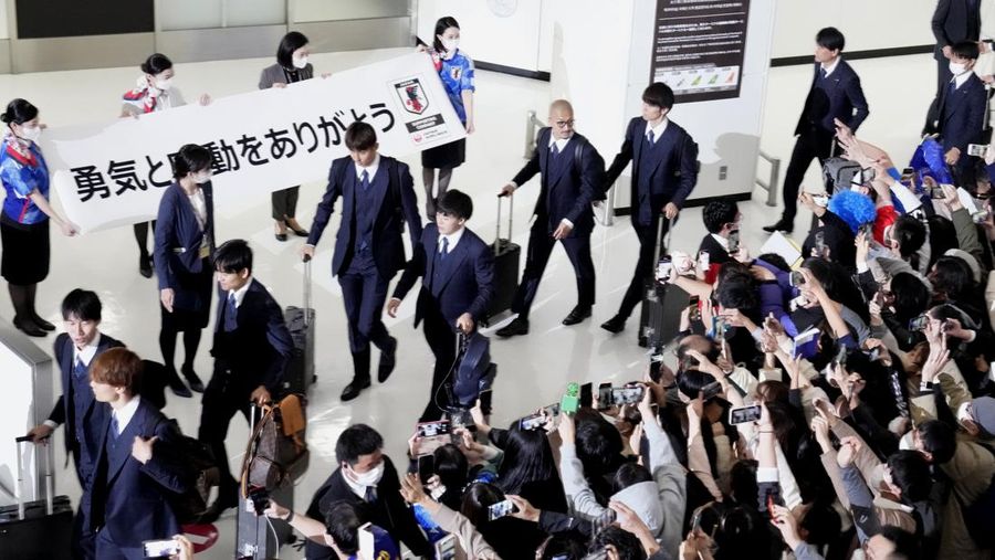 Supporters take photos of the Japanese national soccer team, including head coach Hajime Moriyasu, returning from the World Cup in Qatar at Narita International Airport in Narita, east of Tokyo Japan December 7, 2022. Mandatory credit Kyodo/via REUTERS ATTENTION EDITORS - THIS IMAGE WAS PROVIDED BY A THIRD PARTY. MANDATORY CREDIT. JAPAN OUT. NO COMMERCIAL OR EDITORIAL SALES IN JAPAN
