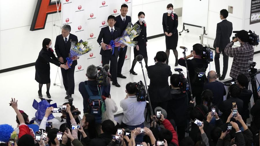 Supporters take photos of the Japanese national soccer team, including head coach Hajime Moriyasu, returning from the World Cup in Qatar at Narita International Airport in Narita, east of Tokyo Japan December 7, 2022. Mandatory credit Kyodo/via REUTERS ATTENTION EDITORS - THIS IMAGE WAS PROVIDED BY A THIRD PARTY. MANDATORY CREDIT. JAPAN OUT. NO COMMERCIAL OR EDITORIAL SALES IN JAPAN