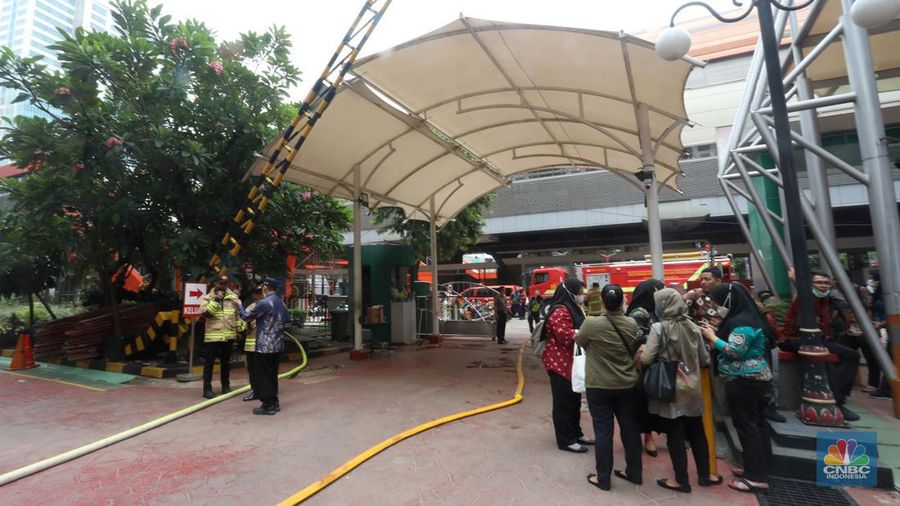 Sejumlah karyawan keluar gedung usai terjadi kebakaran di gedung Imigrasi Kantor Kementerian Hukum dan Hak Asasi Manusia (Kemenkumham), di Jl HR Rasuna Said, Jakarta Selatan, Kamis (8/12/2022). Dinas Penanggulangan Kebakaran dan Penyelamatan (Gulkarmat) DKI Jakarta mengerahkan 25 mobil pemadam kebakaran untuk menjinakkan si jago merah. (CNBC Indonesia/Andrean Kristianto)