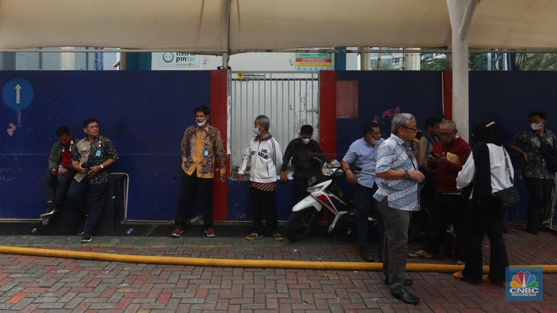 Sejumlah karyawan keluar gedung usai terjadi kebakaran di gedung Imigrasi Kantor Kementerian Hukum dan Hak Asasi Manusia (Kemenkumham), di Jl HR Rasuna Said, Jakarta Selatan, Kamis (8/12/2022). Dinas Penanggulangan Kebakaran dan Penyelamatan (Gulkarmat) DKI Jakarta mengerahkan 25 mobil pemadam kebakaran untuk menjinakkan si jago merah. (CNBC Indonesia/Andrean Kristianto)