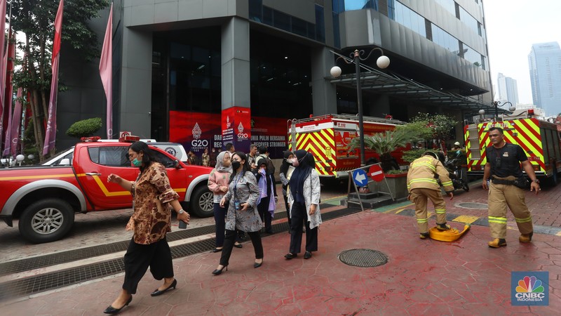 Sejumlah karyawan keluar gedung usai terjadi kebakaran di gedung Imigrasi Kantor Kementerian Hukum dan Hak Asasi Manusia (Kemenkumham), di Jl HR Rasuna Said, Jakarta Selatan, Kamis (8/12/2022). Sejumlah karyawan keluar gedung usai terjadi kebakaran di gedung Imigrasi Kantor Kementerian Hukum dan Hak Asasi Manusia (Kemenkumham), di Jl HR Rasuna Said, Jakarta Selatan, Kamis (8/12/2022). Dinas Penanggulangan Kebakaran dan Penyelamatan (Gulkarmat) DKI Jakarta mengerahkan 25 mobil pemadam kebakaran untuk menjinakkan si jago merah. (CNBC Indonesia/Andrean Kristianto)