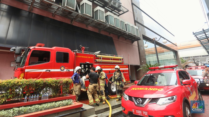 Sejumlah karyawan keluar gedung usai terjadi kebakaran di gedung Imigrasi Kantor Kementerian Hukum dan Hak Asasi Manusia (Kemenkumham), di Jl HR Rasuna Said, Jakarta Selatan, Kamis (8/12/2022). Sejumlah karyawan keluar gedung usai terjadi kebakaran di gedung Imigrasi Kantor Kementerian Hukum dan Hak Asasi Manusia (Kemenkumham), di Jl HR Rasuna Said, Jakarta Selatan, Kamis (8/12/2022). Dinas Penanggulangan Kebakaran dan Penyelamatan (Gulkarmat) DKI Jakarta mengerahkan 25 mobil pemadam kebakaran untuk menjinakkan si jago merah. (CNBC Indonesia/Andrean Kristianto)