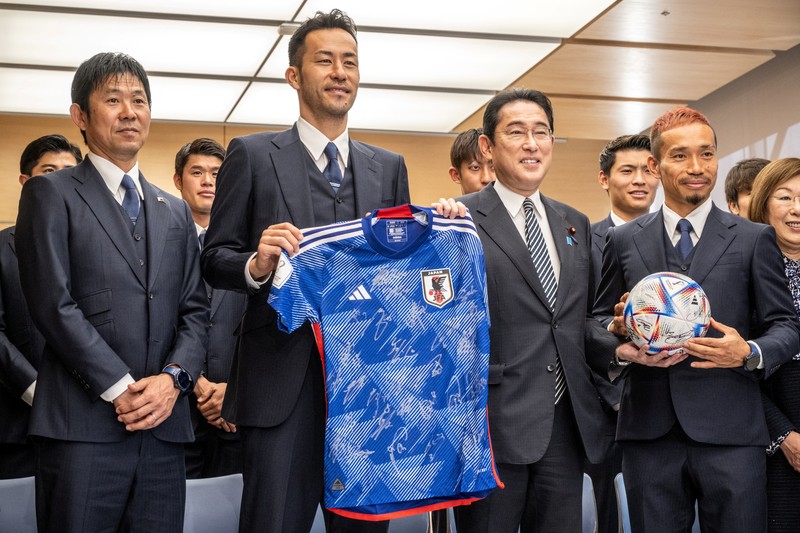 Supporters take photos of the Japanese national soccer team, including head coach Hajime Moriyasu, returning from the World Cup in Qatar at Narita International Airport in Narita, east of Tokyo Japan December 7, 2022. Mandatory credit Kyodo/via REUTERS ATTENTION EDITORS - THIS IMAGE WAS PROVIDED BY A THIRD PARTY. MANDATORY CREDIT. JAPAN OUT. NO COMMERCIAL OR EDITORIAL SALES IN JAPAN
