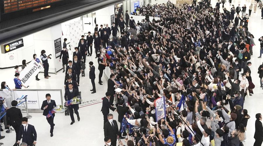 Supporters take photos of the Japanese national soccer team, including head coach Hajime Moriyasu, returning from the World Cup in Qatar at Narita International Airport in Narita, east of Tokyo Japan December 7, 2022. Mandatory credit Kyodo/via REUTERS ATTENTION EDITORS - THIS IMAGE WAS PROVIDED BY A THIRD PARTY. MANDATORY CREDIT. JAPAN OUT. NO COMMERCIAL OR EDITORIAL SALES IN JAPAN