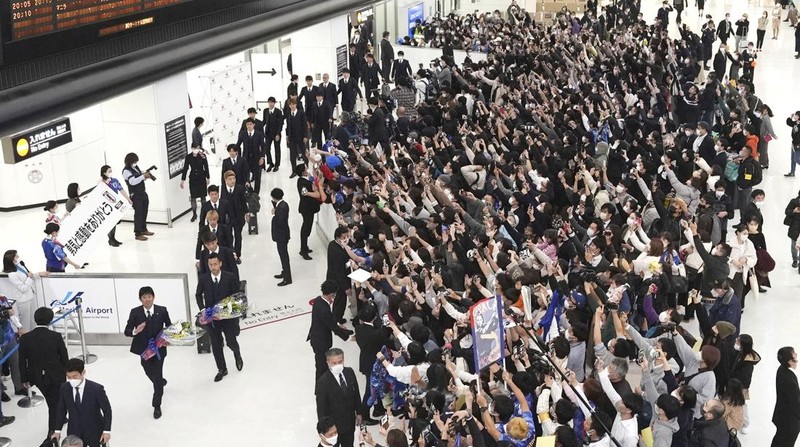 Supporters take photos of the Japanese national soccer team, including head coach Hajime Moriyasu, returning from the World Cup in Qatar at Narita International Airport in Narita, east of Tokyo Japan December 7, 2022. Mandatory credit Kyodo/via REUTERS ATTENTION EDITORS - THIS IMAGE WAS PROVIDED BY A THIRD PARTY. MANDATORY CREDIT. JAPAN OUT. NO COMMERCIAL OR EDITORIAL SALES IN JAPAN