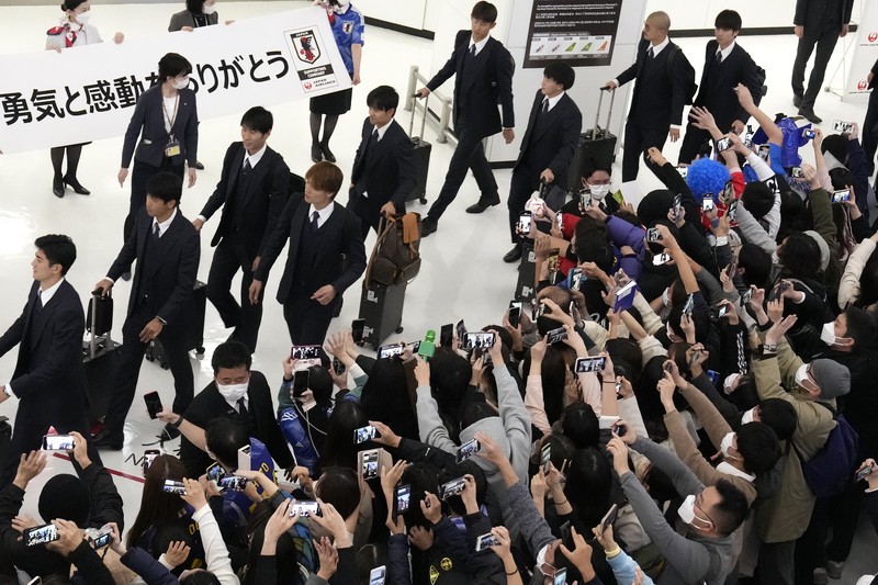 Supporters take photos of the Japanese national soccer team, including head coach Hajime Moriyasu, returning from the World Cup in Qatar at Narita International Airport in Narita, east of Tokyo Japan December 7, 2022. Mandatory credit Kyodo/via REUTERS ATTENTION EDITORS - THIS IMAGE WAS PROVIDED BY A THIRD PARTY. MANDATORY CREDIT. JAPAN OUT. NO COMMERCIAL OR EDITORIAL SALES IN JAPAN