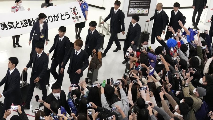 Supporters take photos of the Japanese national soccer team, including head coach Hajime Moriyasu, returning from the World Cup in Qatar at Narita International Airport in Narita, east of Tokyo Japan December 7, 2022. Mandatory credit Kyodo/via REUTERS ATTENTION EDITORS - THIS IMAGE WAS PROVIDED BY A THIRD PARTY. MANDATORY CREDIT. JAPAN OUT. NO COMMERCIAL OR EDITORIAL SALES IN JAPAN