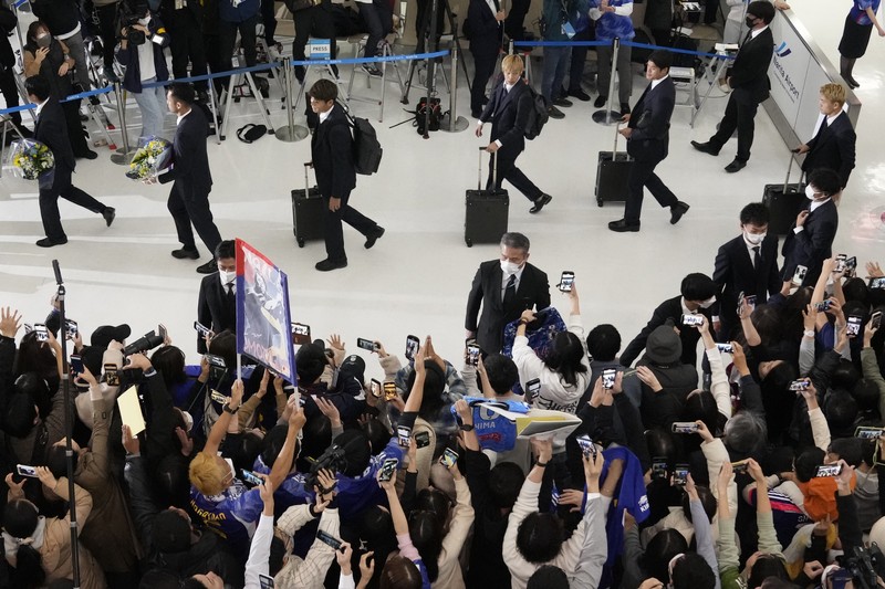Supporters take photos of the Japanese national soccer team, including head coach Hajime Moriyasu, returning from the World Cup in Qatar at Narita International Airport in Narita, east of Tokyo Japan December 7, 2022. Mandatory credit Kyodo/via REUTERS ATTENTION EDITORS - THIS IMAGE WAS PROVIDED BY A THIRD PARTY. MANDATORY CREDIT. JAPAN OUT. NO COMMERCIAL OR EDITORIAL SALES IN JAPAN