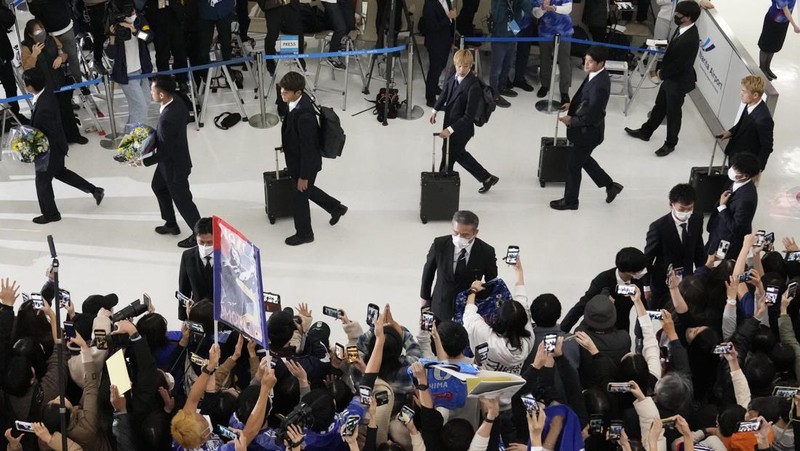 Supporters take photos of the Japanese national soccer team, including head coach Hajime Moriyasu, returning from the World Cup in Qatar at Narita International Airport in Narita, east of Tokyo Japan December 7, 2022. Mandatory credit Kyodo/via REUTERS ATTENTION EDITORS - THIS IMAGE WAS PROVIDED BY A THIRD PARTY. MANDATORY CREDIT. JAPAN OUT. NO COMMERCIAL OR EDITORIAL SALES IN JAPAN