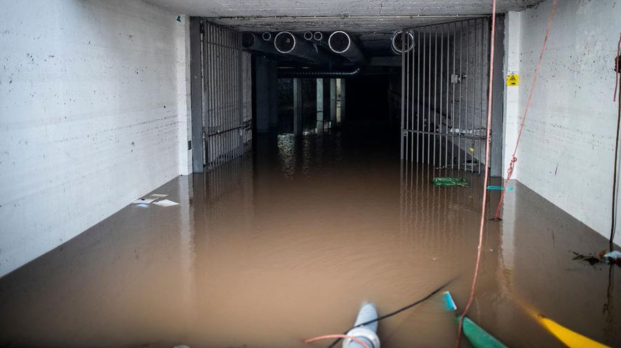 Seorang pria mencoba membuang air berlumpur setelah banjir di Lisbon pada 8 Desember 2022. - Satu orang meninggal tadi malam akibat banjir di wilayah Lisbon, dilanda hujan lebat, kata dinas pertahanan sipil. (CARLOS COSTA/AFP via Getty Images)