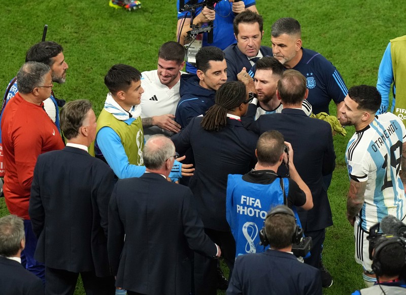 Penyerang #10 Argentina Lionel Messi (Tengah) berbicara dengan mantan pemain Belanda Edgar Davids saat ia merayakan kemenangan pertandingan sepak bola perempat final Piala Dunia Qatar 2022 antara Belanda dan Argentina di Stadion Lusail, utara Doha pada 9 Desember 2022. Penyerang #10 Argentina Lionel Messi (Tengah) berbicara dengan mantan pemain Belanda Edgar Davids saat ia merayakan kemenangan pertandingan sepak bola perempat final Piala Dunia Qatar 2022 antara Belanda dan Argentina di Stadion Lusail, utara Doha pada 9 Desember 2022. (FRANCK FIFE/AFP via Getty Images)