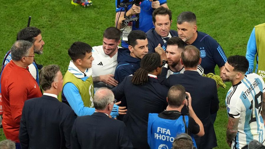 Penyerang #10 Argentina Lionel Messi (Tengah) berbicara dengan mantan pemain Belanda Edgar Davids saat ia merayakan kemenangan pertandingan sepak bola perempat final Piala Dunia Qatar 2022 antara Belanda dan Argentina di Stadion Lusail, utara Doha pada 9 Desember 2022. (FRANCK FIFE/AFP via Getty Images)