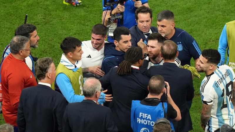 Penyerang #10 Argentina Lionel Messi (Tengah) berbicara dengan mantan pemain Belanda Edgar Davids saat ia merayakan kemenangan pertandingan sepak bola perempat final Piala Dunia Qatar 2022 antara Belanda dan Argentina di Stadion Lusail, utara Doha pada 9 Desember 2022. (FRANCK FIFE/AFP via Getty Images)