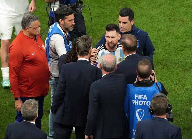 Penyerang #10 Argentina Lionel Messi (Tengah) berbicara dengan mantan pemain Belanda Edgar Davids saat ia merayakan kemenangan pertandingan sepak bola perempat final Piala Dunia Qatar 2022 antara Belanda dan Argentina di Stadion Lusail, utara Doha pada 9 Desember 2022. Penyerang #10 Argentina Lionel Messi (Tengah) berbicara dengan mantan pemain Belanda Edgar Davids saat ia merayakan kemenangan pertandingan sepak bola perempat final Piala Dunia Qatar 2022 antara Belanda dan Argentina di Stadion Lusail, utara Doha pada 9 Desember 2022. (FRANCK FIFE/AFP via Getty Images)