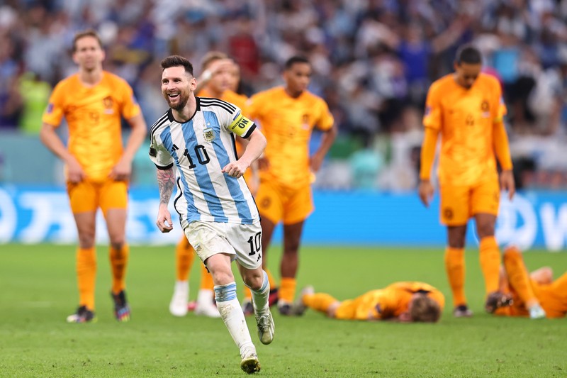 Penyerang #10 Argentina Lionel Messi (Tengah) berbicara dengan mantan pemain Belanda Edgar Davids saat ia merayakan kemenangan pertandingan sepak bola perempat final Piala Dunia Qatar 2022 antara Belanda dan Argentina di Stadion Lusail, utara Doha pada 9 Desember 2022. Penyerang #10 Argentina Lionel Messi (Tengah) berbicara dengan mantan pemain Belanda Edgar Davids saat ia merayakan kemenangan pertandingan sepak bola perempat final Piala Dunia Qatar 2022 antara Belanda dan Argentina di Stadion Lusail, utara Doha pada 9 Desember 2022. (FRANCK FIFE/AFP via Getty Images)