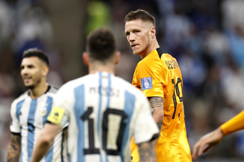 Penyerang #10 Argentina Lionel Messi (Tengah) berbicara dengan mantan pemain Belanda Edgar Davids saat ia merayakan kemenangan pertandingan sepak bola perempat final Piala Dunia Qatar 2022 antara Belanda dan Argentina di Stadion Lusail, utara Doha pada 9 Desember 2022. (FRANCK FIFE/AFP via Getty Images)